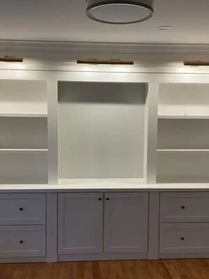 White and gray built-in cabinetry with open shelves and center display niche, recessed lighting