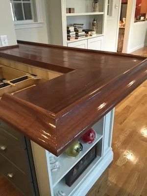 Walnut wood kitchen island countertop with finished edges and open shelving storage