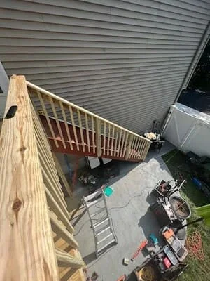 Newly constructed pressure-treated wood deck with railings and stairs, overhead view