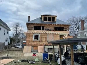Multi-story brick addition under construction with detailed masonry work and framed upper level
