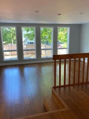 Open interior space with four glass panel doors, hardwood flooring, and recessed lighting