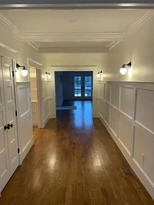Hallway with white wainscoting, hardwood flooring, and recessed lighting
