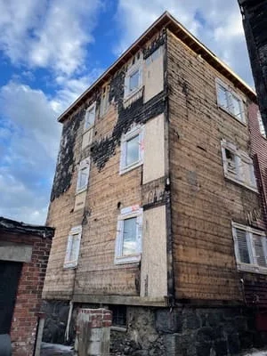 Multi-story stone and brick building facade with restored masonry and new cladding panels